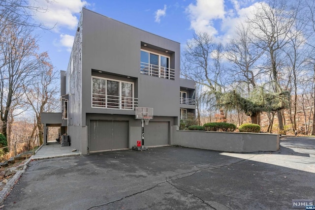 view of front of home with a garage and central air condition unit