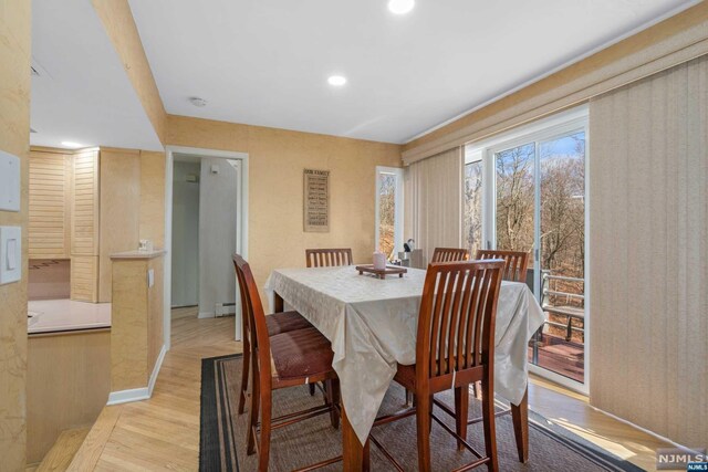 dining space featuring light wood-type flooring and baseboard heating