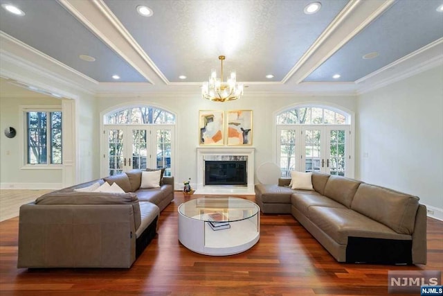 living room with a notable chandelier, dark hardwood / wood-style floors, and french doors