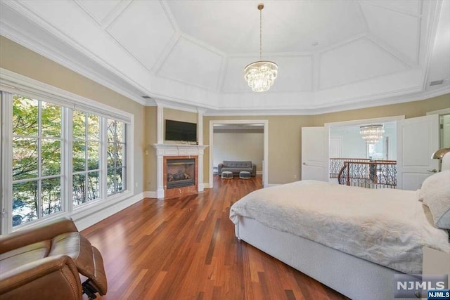 bedroom featuring dark hardwood / wood-style flooring, ornamental molding, and an inviting chandelier