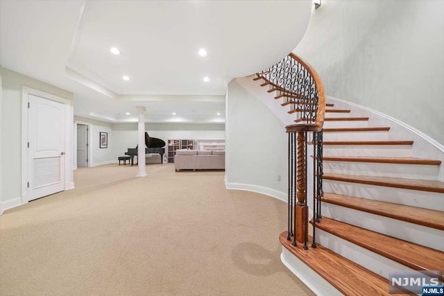 stairs with carpet flooring and a tray ceiling