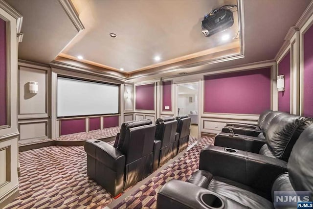 home theater room featuring carpet flooring, crown molding, and a tray ceiling