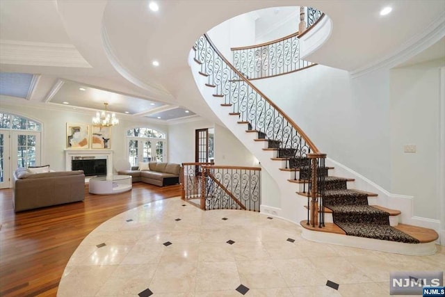 stairway with french doors, ornamental molding, coffered ceiling, beam ceiling, and hardwood / wood-style floors