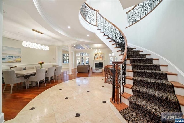 foyer featuring hardwood / wood-style floors, ornamental molding, and a chandelier