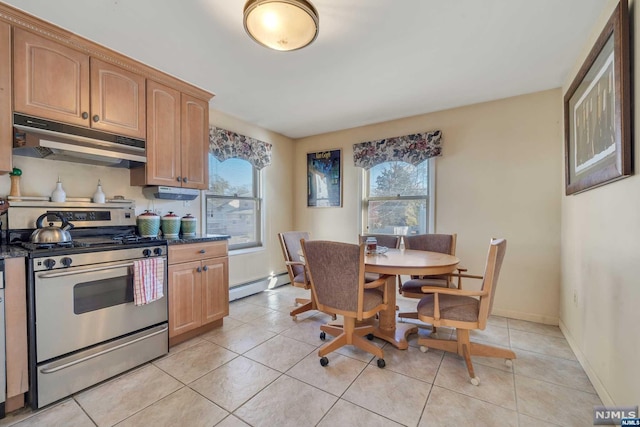 kitchen with a baseboard heating unit, stainless steel gas range, a wealth of natural light, and light tile patterned flooring