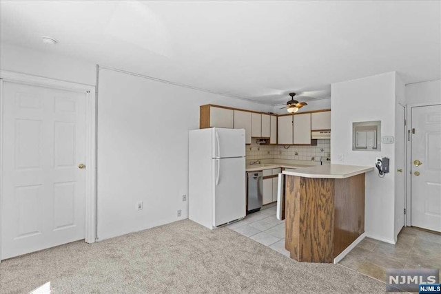 kitchen with light carpet, backsplash, and white fridge