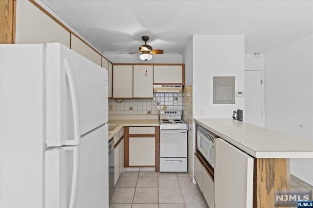 kitchen with kitchen peninsula, tasteful backsplash, white appliances, range hood, and light tile patterned flooring