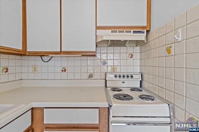 kitchen featuring white electric range, backsplash, and white cabinetry