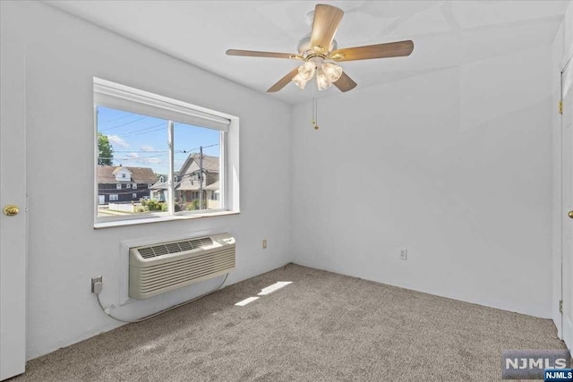 unfurnished room with carpet flooring, an AC wall unit, and ceiling fan