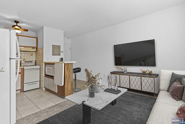 tiled living room featuring ceiling fan and electric panel