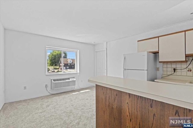 kitchen with a wall unit AC, light carpet, tasteful backsplash, and white fridge