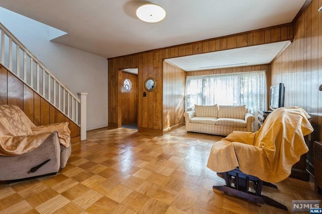 living room with light parquet flooring and wooden walls