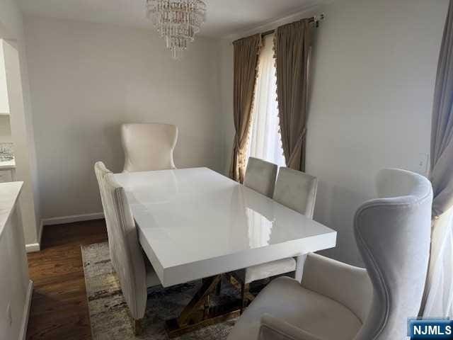 dining area featuring dark hardwood / wood-style flooring and a chandelier