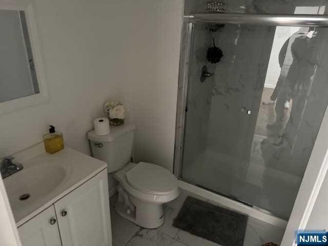 bathroom featuring vanity, toilet, and walk in shower