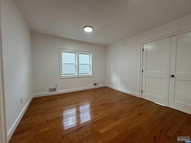 unfurnished bedroom with wood-type flooring and a closet