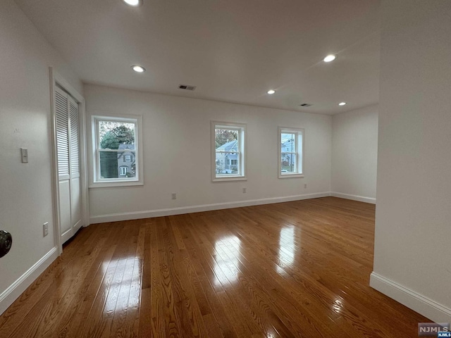 spare room featuring a healthy amount of sunlight and hardwood / wood-style flooring