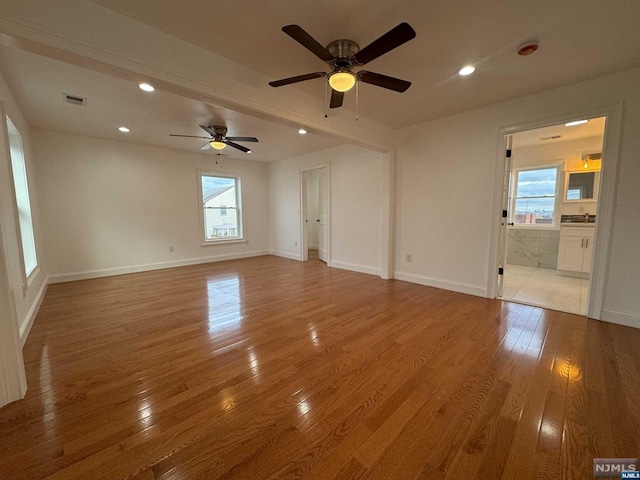 unfurnished room with light hardwood / wood-style flooring, plenty of natural light, and ceiling fan