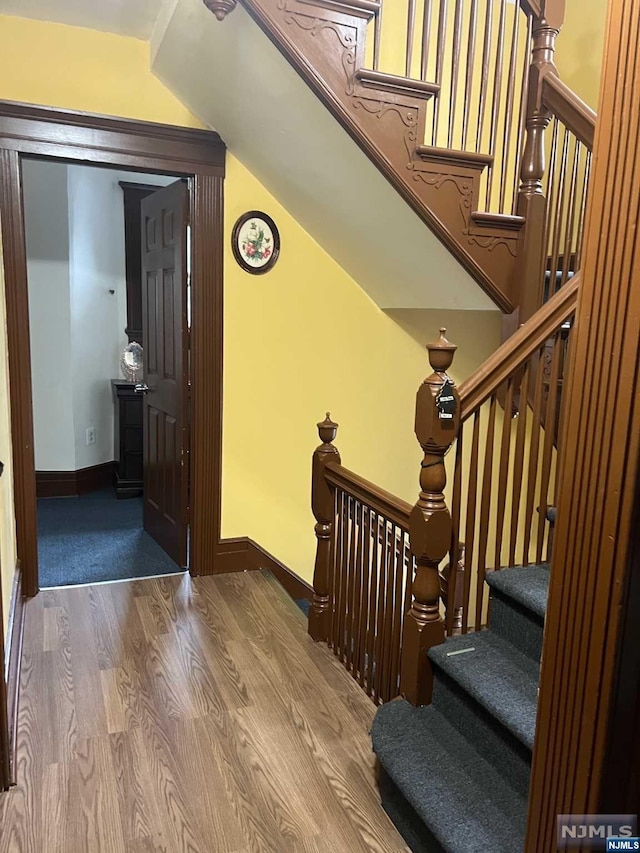 stairs with wood-type flooring and vaulted ceiling