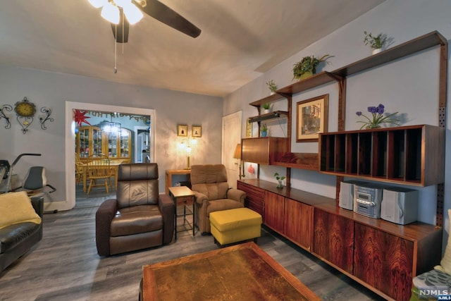 living room with ceiling fan and dark wood-type flooring