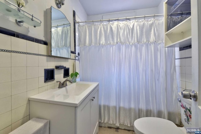 bathroom with decorative backsplash, vanity, toilet, and tile walls