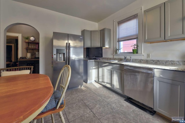 kitchen with light tile patterned floors, stainless steel appliances, gray cabinets, and sink