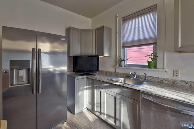 kitchen featuring sink, gray cabinets, light tile patterned floors, light stone countertops, and appliances with stainless steel finishes