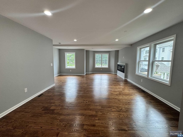 unfurnished living room with dark wood-type flooring