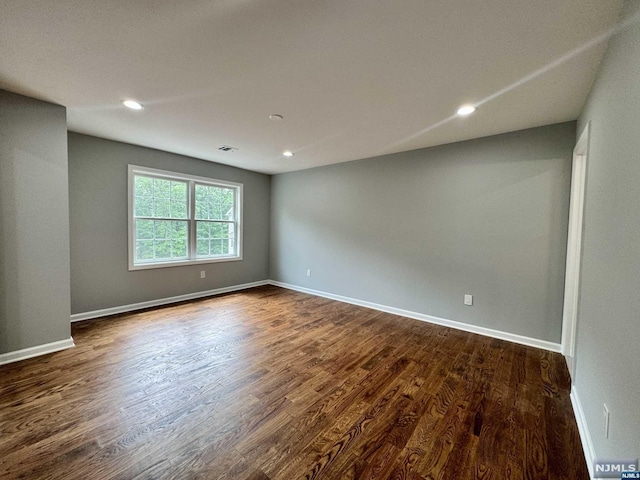 spare room featuring dark wood-type flooring