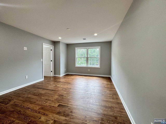 unfurnished room with dark hardwood / wood-style flooring