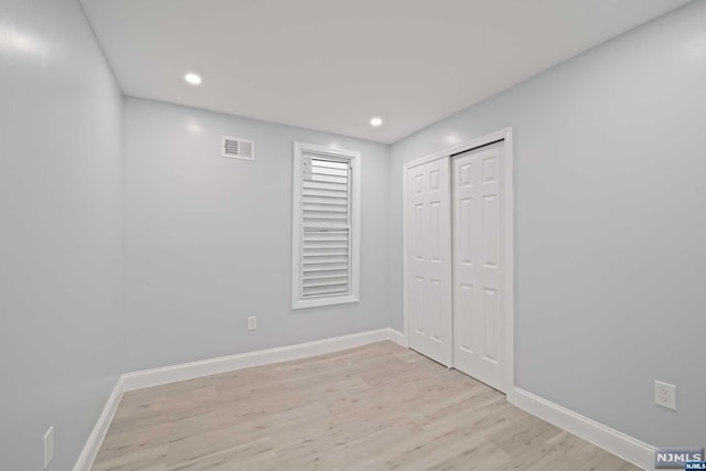 unfurnished bedroom featuring a closet and light hardwood / wood-style flooring