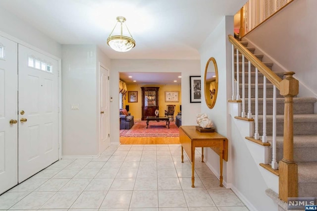 foyer featuring light tile patterned flooring, recessed lighting, stairs, and baseboards