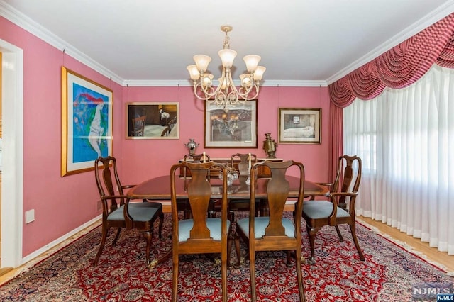 dining room featuring baseboards, a chandelier, and ornamental molding