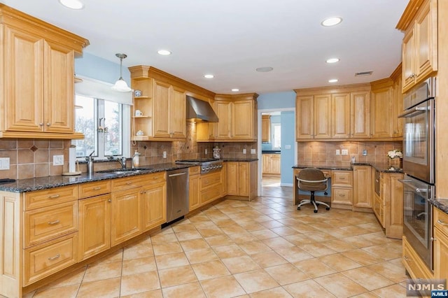 kitchen featuring visible vents, a sink, stainless steel appliances, dark stone counters, and wall chimney exhaust hood