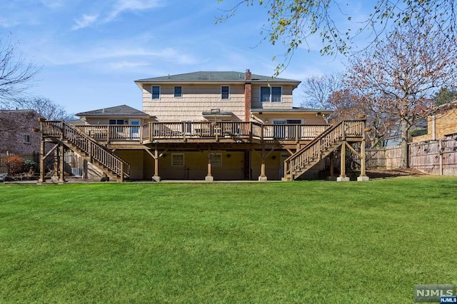 back of house featuring a lawn, stairs, and fence