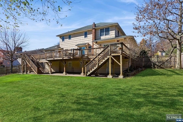 rear view of property with a yard, a wooden deck, stairs, and a fenced backyard