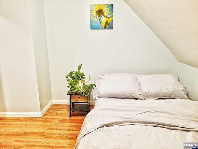 bedroom featuring lofted ceiling and wood-type flooring