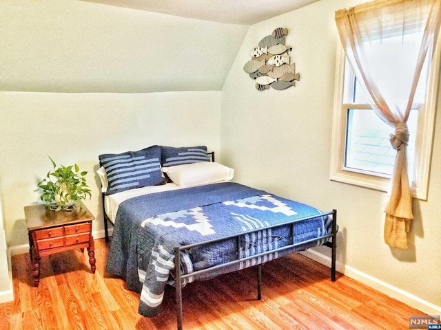 bedroom featuring wood-type flooring and vaulted ceiling