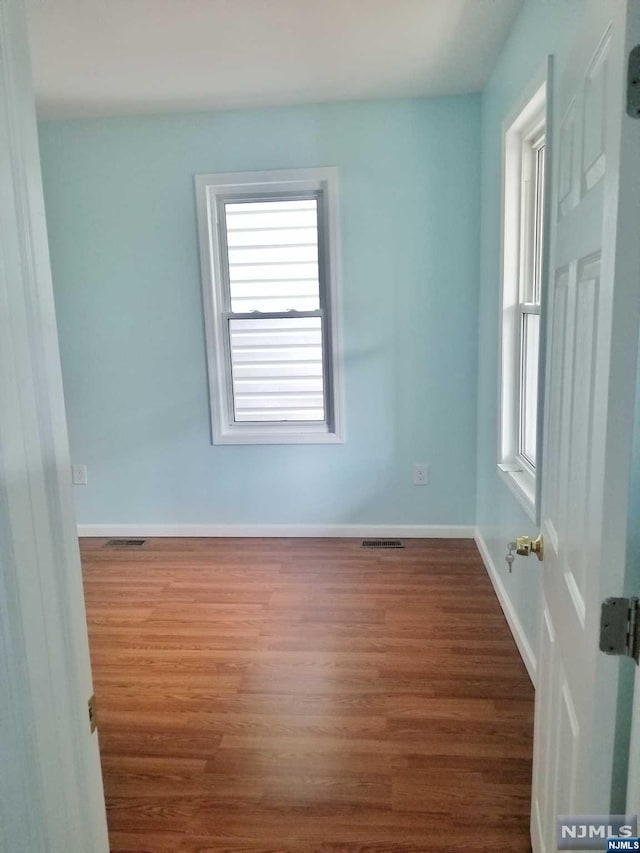 empty room with hardwood / wood-style flooring