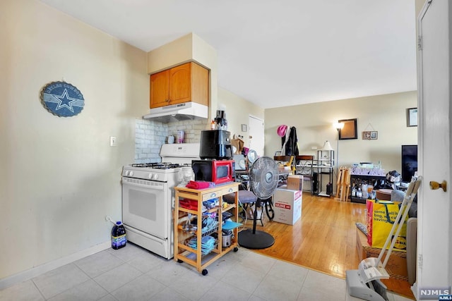 kitchen with tasteful backsplash, white range with gas stovetop, and light hardwood / wood-style floors