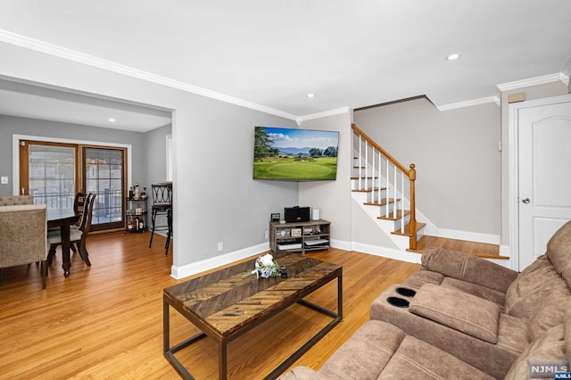 living room with light hardwood / wood-style flooring and crown molding