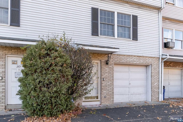 entrance to property with a garage and cooling unit