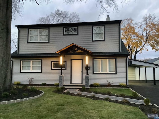 view of front of house with a front yard and a carport