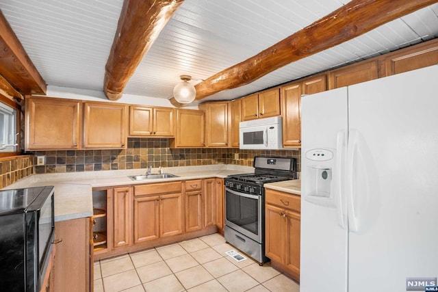 kitchen featuring sink, tasteful backsplash, beamed ceiling, light tile patterned floors, and appliances with stainless steel finishes