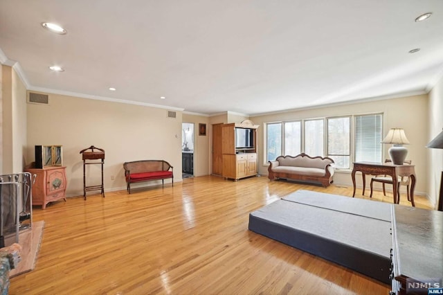 living room featuring light hardwood / wood-style floors and crown molding