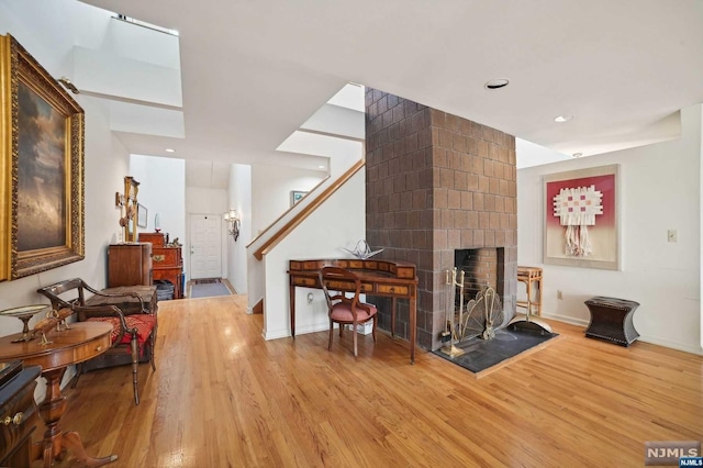 living room with a brick fireplace and light hardwood / wood-style flooring