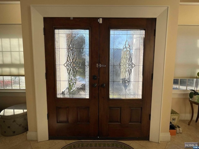 foyer featuring light tile patterned floors and french doors