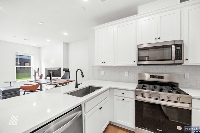 kitchen featuring decorative backsplash, sink, white cabinets, and stainless steel appliances