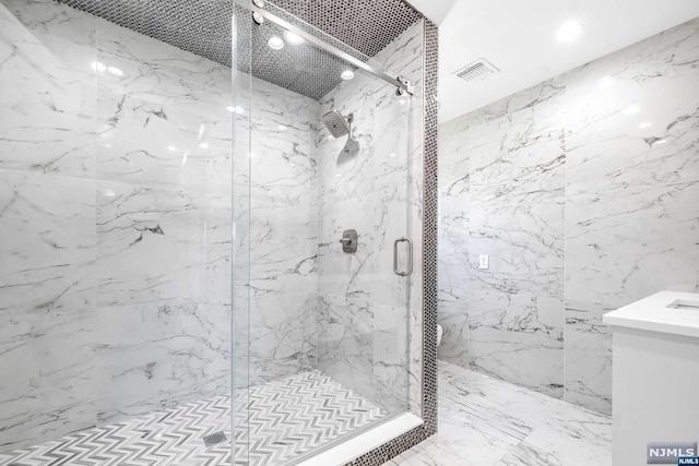 bathroom with a shower with door and vanity