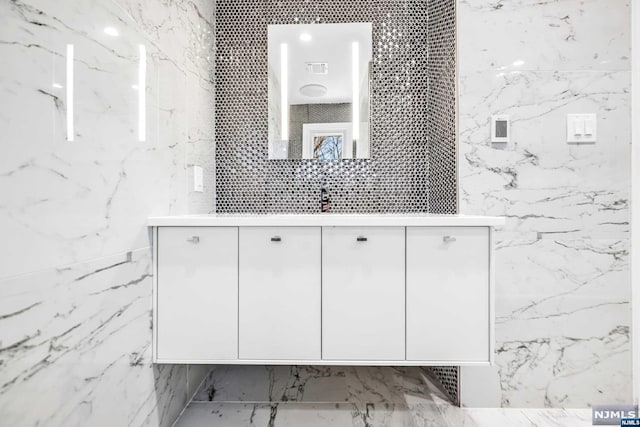 bathroom with vanity and tile walls