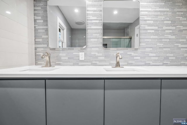 bathroom with vanity and tasteful backsplash